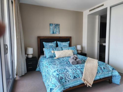 金斯顿Lakefront Views on the foreshore的一间卧室配有一张蓝色的床,上面有泰迪熊