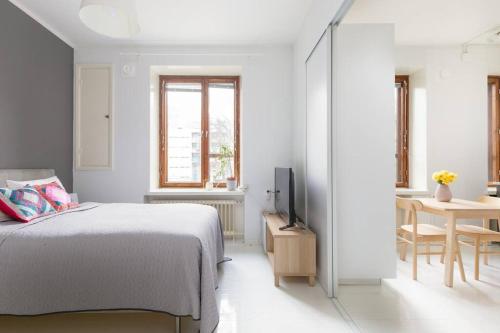 赫尔辛基Charming suite with garden and free parking的白色卧室配有床和桌子