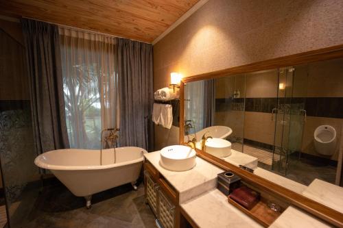 顺安4br Villa River Deck, Pool, Bbq & Garden的一间带浴缸和大镜子的浴室