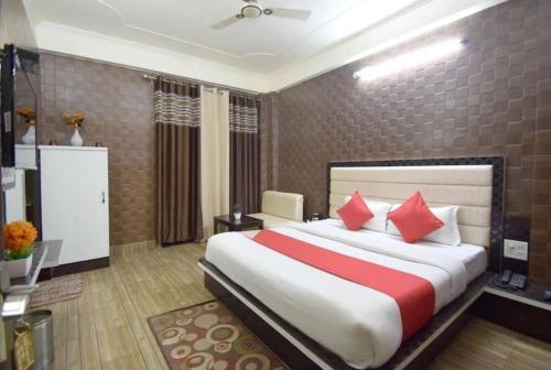 布巴内什瓦尔Goroomgo Om Sai Residency Bhubaneswar的一间卧室配有一张带红色枕头的大床