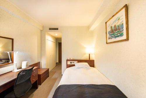 宇都宫HOTEL NEWITAYA的配有一张床和一张书桌的酒店客房