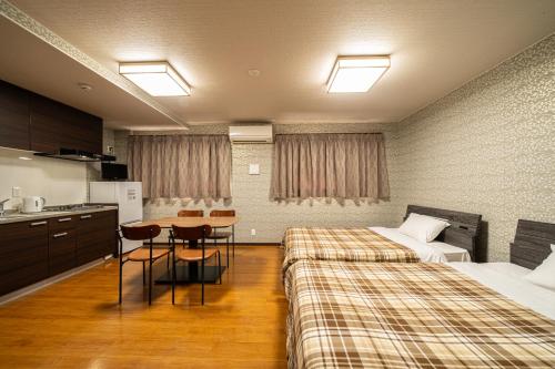 别府BEPPU HOSTEL U&T的酒店客房设有两张床和一张桌子。