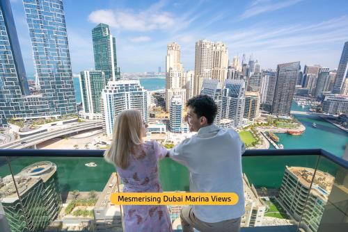 迪拜温德姆迪拜码头酒店的站在摩天大楼顶上的男人和女人