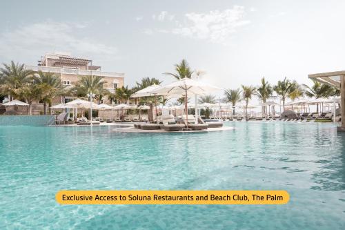 迪拜温德姆迪拜码头酒店的度假村内带椅子和遮阳伞的游泳池