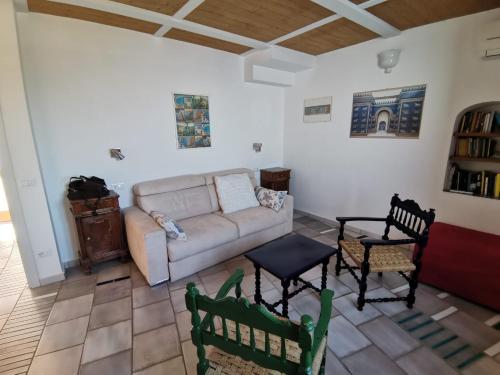 弗洛里Il Nido Del Falco - Art house with terrace and sea view的客厅配有沙发和两把椅子