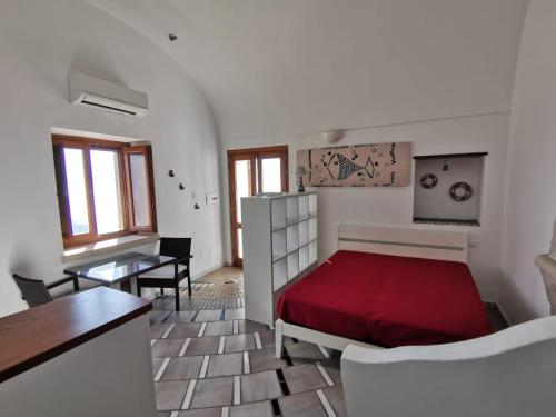 弗洛里Il Nido Del Falco - Art house with terrace and sea view的一间卧室配有红色的床和一张桌子