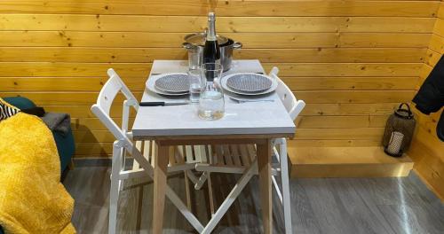 Dannemarie-sur-CrêteTiny House - Home-One的一张带盘子和玻璃杯的白色桌子