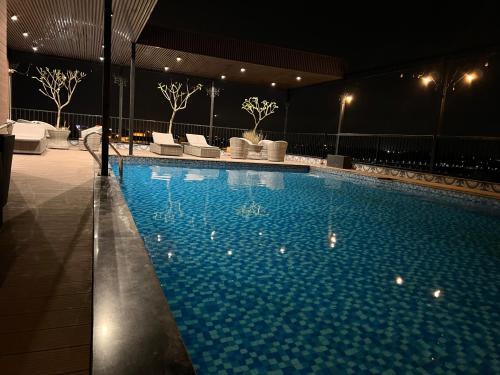 河内Paragon Noi bai Hotel & Pool的大楼内带椅子和灯的大型游泳池
