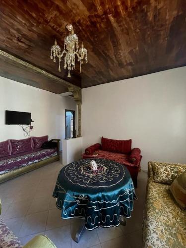 马拉喀什Route de la jnane awrad lotissement 14 immeuble 5 étage 4 appartement 20 Marrakech的客厅配有桌子和沙发