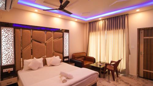曼达莫尼Sea Queen Beach Resort On Beach的配有床、椅子和桌子的酒店客房