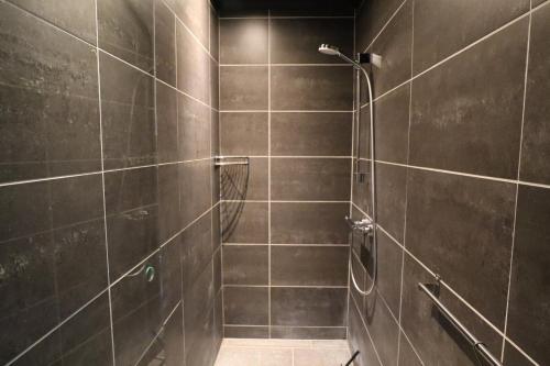 海宁Schellerup Gård的带淋浴的浴室和棕色瓷砖墙壁