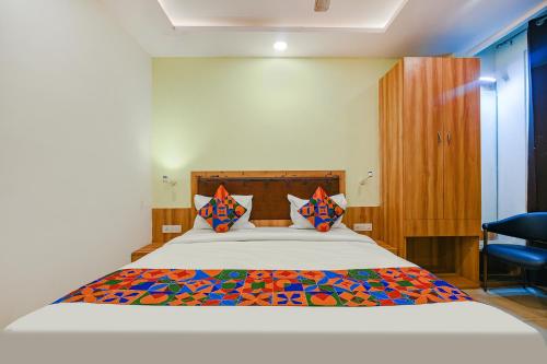 新德里FabHotel Royal Residency I的一间卧室配有一张带色彩缤纷枕头的大床