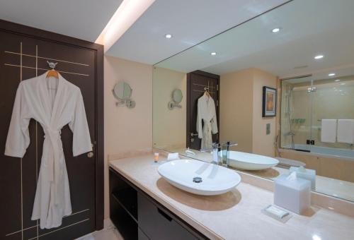迪拜迪拜广场凯悦公寓式酒店的浴室设有水槽,门上挂着长袍