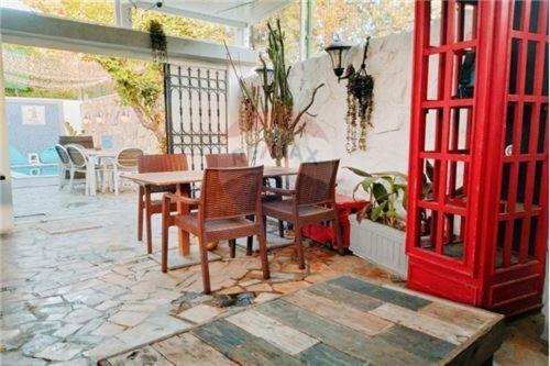 El MaamouraH.younes的一个带桌椅的庭院和一扇红色的门