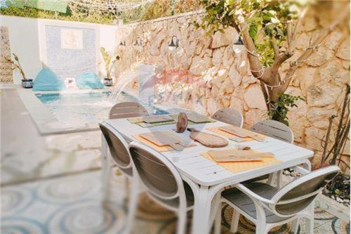 El MaamouraH.younes的一个带游泳池的庭院里配有一张白色的桌子和椅子