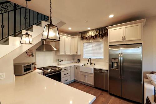 圣地亚哥Modern comfort, prime location, 360 views, 4 BR entire house的厨房配有白色橱柜和不锈钢冰箱