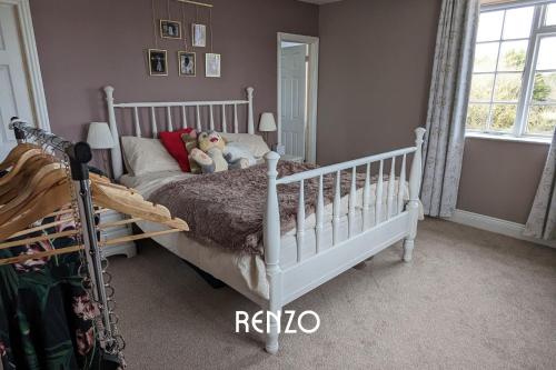 Burton JoyceHomely 4-bed Home in Nottingham by Renzo, Peaceful Location, Sleeps 8!的卧室配有白色婴儿床,上面有两只填充动物