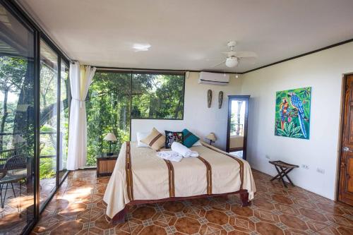 曼努埃尔安东尼奥Mango Moon Villa的一间卧室设有一张床和一个大窗户