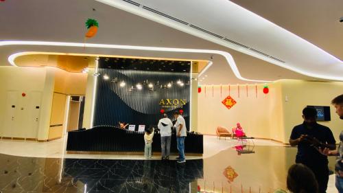吉隆坡Axon suites by GALAXY HOUSE的两个人站在一间阿柯亚商店前