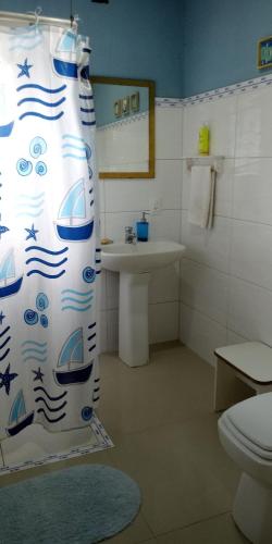 巴拉奈里奥-坎布里乌Quarto na Praia de Taquaras的浴室配有带水槽的浴帘和卫生间