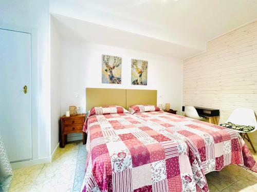阿雷纳斯德圣佩德罗Hostal La Taberna的一间卧室配有一张带红白色棉被的床