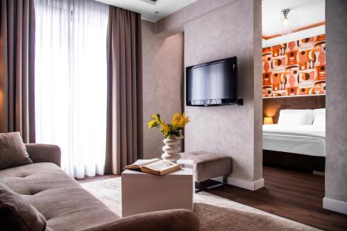 贝尔格莱德Crystal Hotel的带沙发、电视和床的客厅
