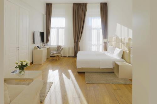 诺维萨德Lanterna Rooms City Center的一间白色的卧室,配有床和客厅