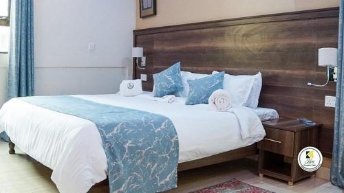 MuhoroniKoru Country Club的一间卧室配有一张大床和木制床头板