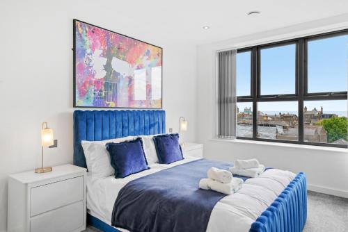 KentRetreat: Seaside Bliss In Ramsgate的卧室配有蓝色和白色的床和窗户。