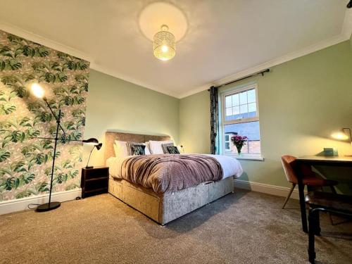 诺丁汉The Lily•Central Beeston•Private Apartment•SmartTV•Free Wi-Fi•Tram•的一间卧室配有一张床、一张书桌和一个窗户。