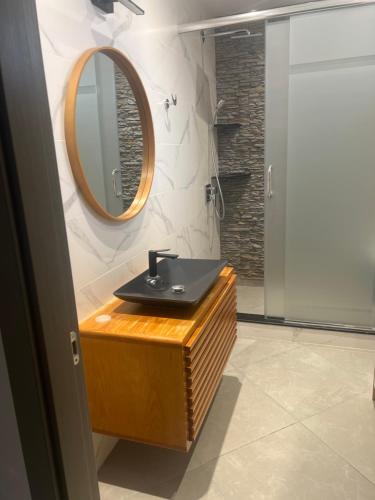阿尔及尔Résidence Djenane malik的浴室设有黑色水槽和镜子