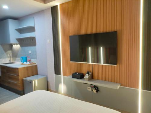 WarungmanggaNewly renovated apartement @ collins boulevard的一间带壁挂式电视的卧室和一间浴室