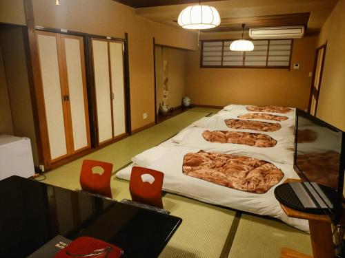 东京艾多亚酒店的一间房间,地板上设有四张大床和红色椅子