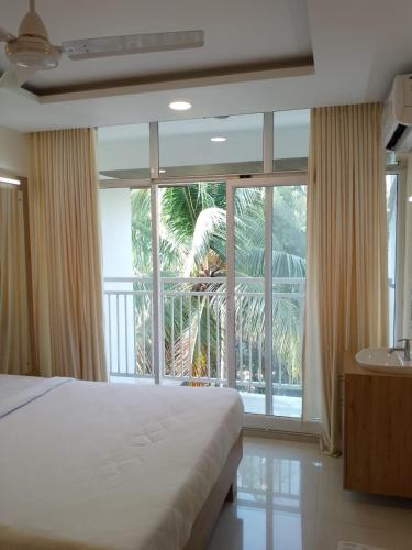 古鲁瓦尤尔Ambalath Ayesha Homes的一间卧室设有一张床和一个大窗户