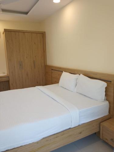 古鲁瓦尤尔Ambalath Ayesha Homes的一间卧室配有带白色床单和枕头的床。