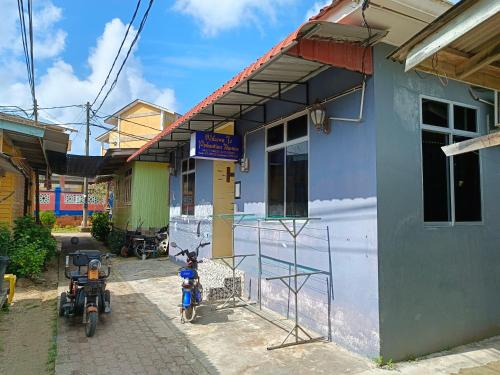 停泊岛Perhentian Idaman的两辆摩托车停在楼前的建筑物
