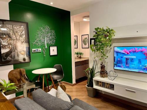 圣保罗Linda vista perto da Paulista com piscina/garagem的客厅设有绿色的墙壁和电视。