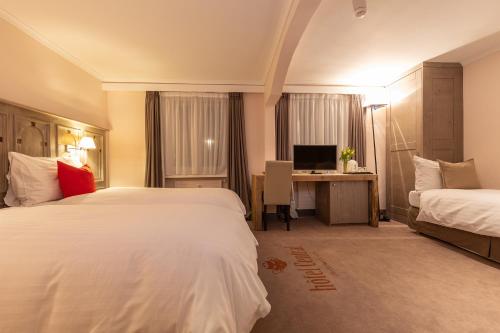 克莱恩 蒙塔纳Hotel Central, Spa & lounge bar的酒店客房配有两张床和一张书桌