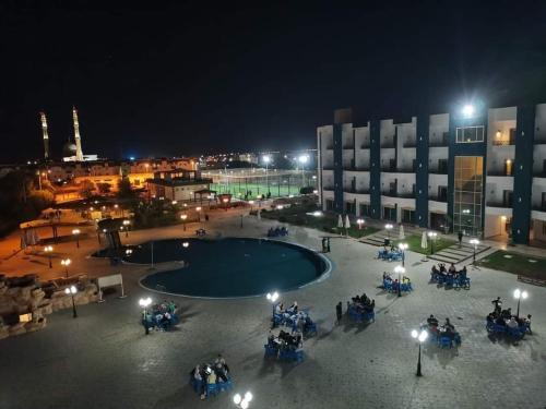 沙姆沙伊赫Sharm el shiekh sports city的一群人晚上坐在游泳池周围