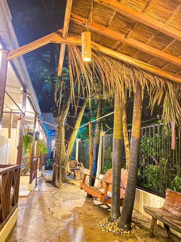 爱妮岛Aquaholik Traveler's Lodge的种有棕榈树和长凳的庭院