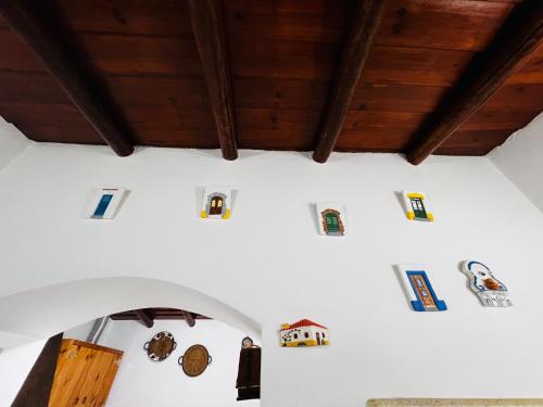 CampinhoÉ um Descanso的客房拥有白色的墙壁和木制天花板,墙上装饰着不同的物品。