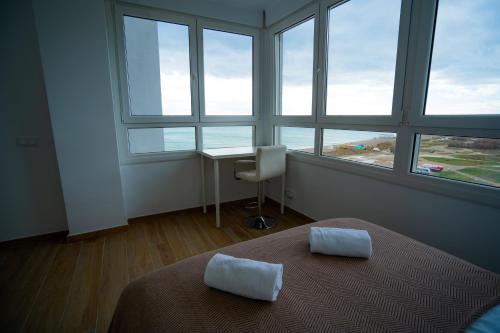 马拉加Sunstay - Seaview Guadalmar的卧室配有一张床、一张书桌和窗户。