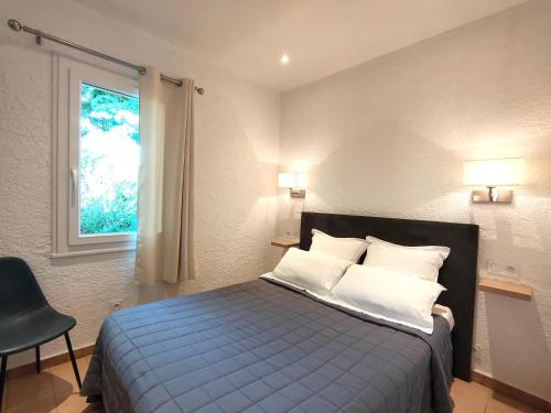 维琪奥港蝉公寓酒店的一间卧室配有蓝色的床、白色枕头和窗户