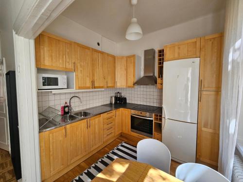斯德哥尔摩Home Inn KG26的厨房配有木制橱柜和白色冰箱。