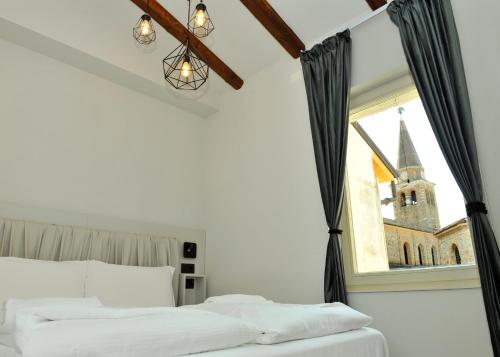 格拉多Ca’ Bruno Masaneta的一间卧室设有一张床,窗户设有教堂