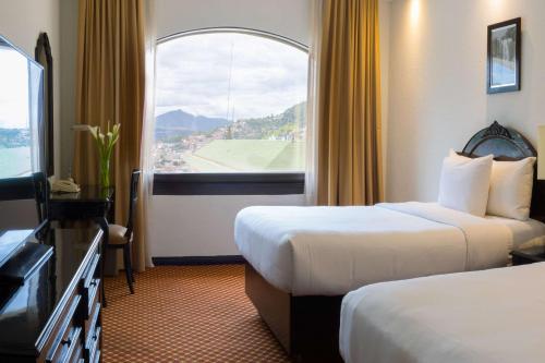 特古西加尔巴特古西加尔巴克拉丽奥酒店 的酒店客房设有两张床和窗户。