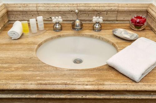 特古西加尔巴特古西加尔巴克拉丽奥酒店 的浴室柜台配有带毛巾和肥皂的盥洗池
