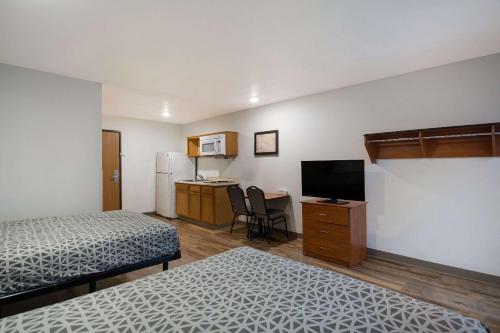 奥古斯塔WoodSpring Suites Augusta Riverwatch的酒店客房设有两张床和电视。