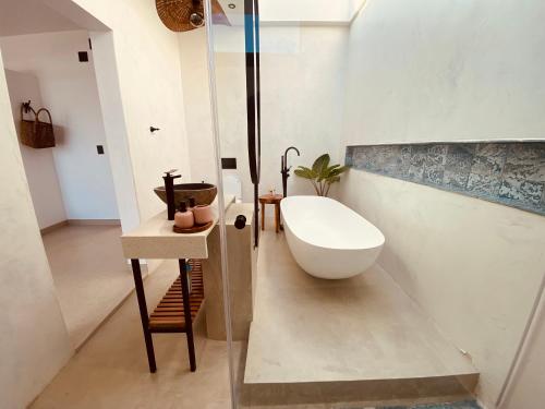 普拉伊拉多比莱尼Villa Luasah的浴室配有盥洗盆和浴缸。