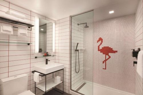 迈阿密Radisson RED Miami Airport的白色的浴室设有水槽和淋浴。